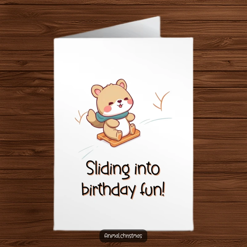 Funny Free Printable Birthday Card: Animal gleefully slides down a snowy hill on a small sled, pure winter fun.